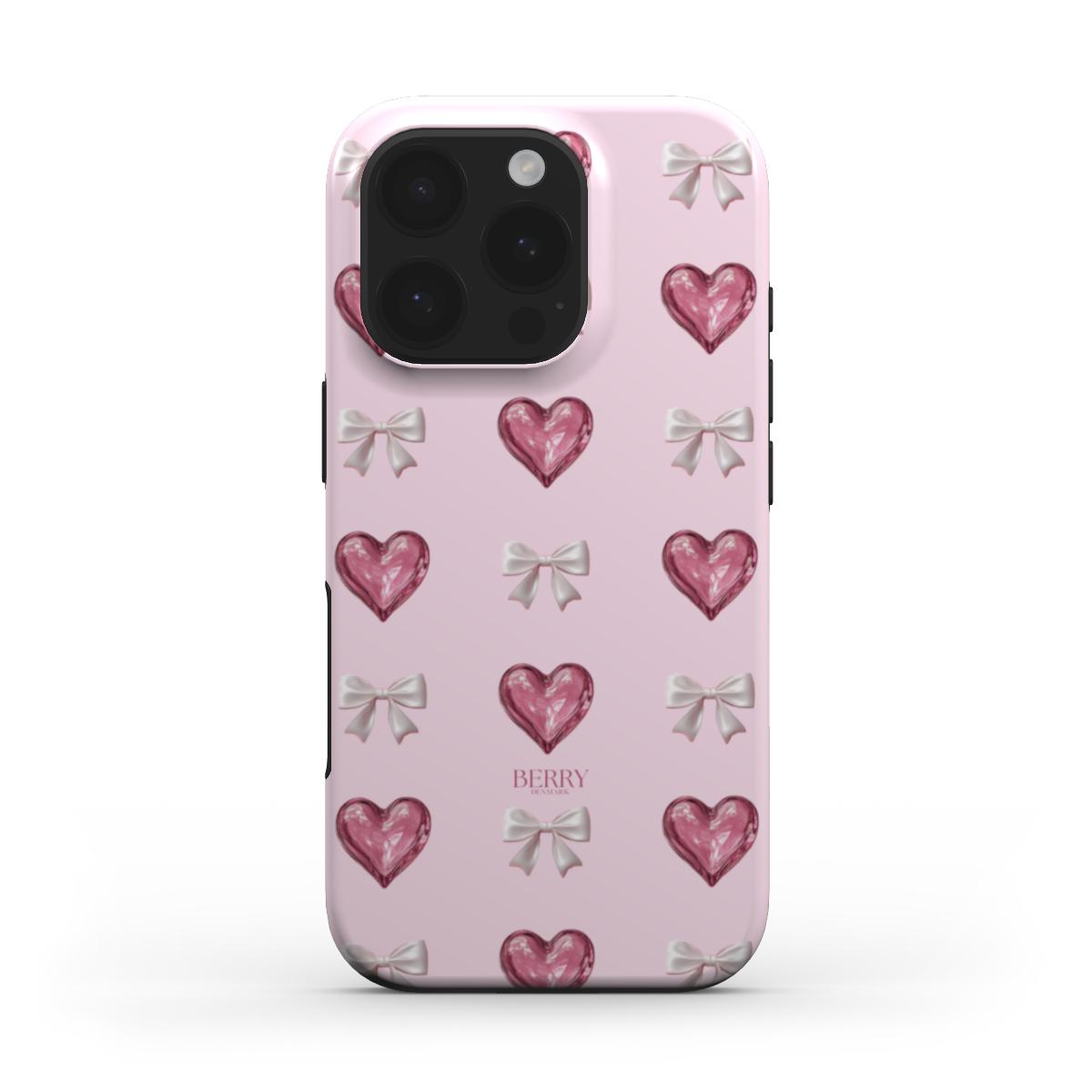 Trendy pink phone case with a girly pattern of multicolored hearts and delicate bows, radiating a feminine and beautiful aesthetic.