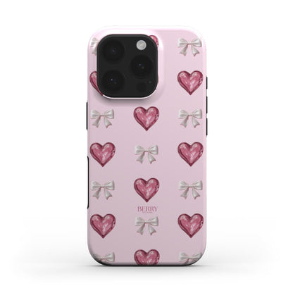 Trendy pink phone case with a girly pattern of multicolored hearts and delicate bows, radiating a feminine and beautiful aesthetic.